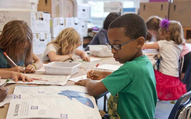Boy writing on white paper