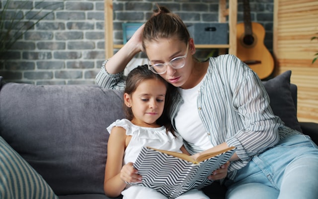 Mother reading aloud to daughter