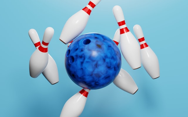 Blue bowling ball crashing into pins