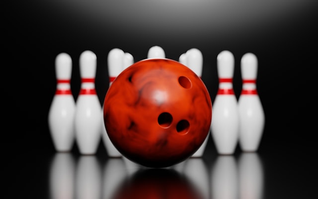 Red bowling ball and white pins