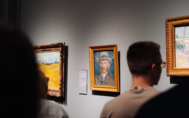 People viewing paintings in a gallery