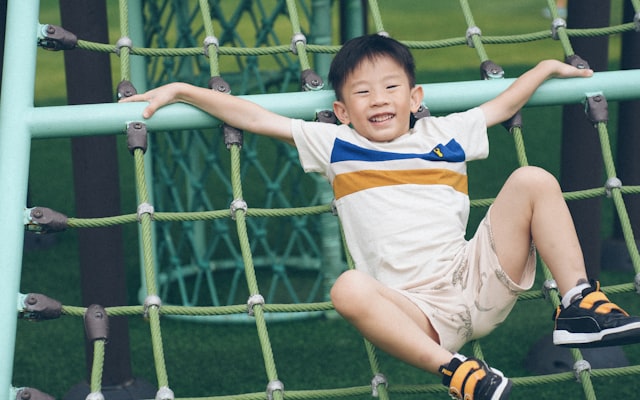 Boy climbing a net structure